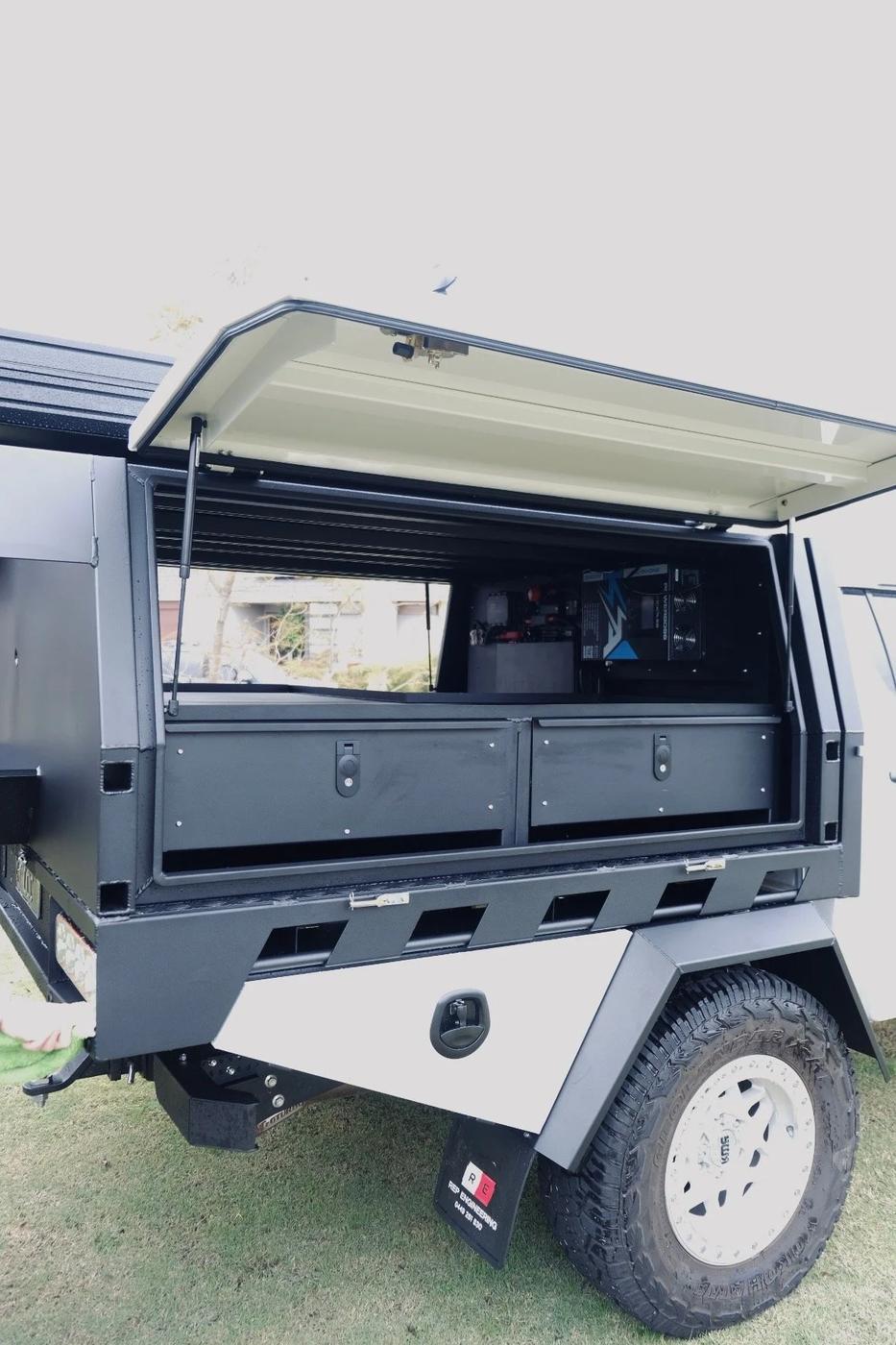 Canopy with gull-wing door open showing drawers and storage