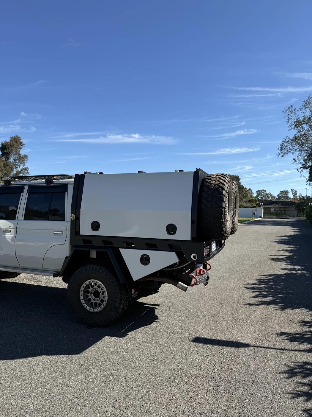 LandCruiser 79 with black aluminium canopy parked on a gravel road